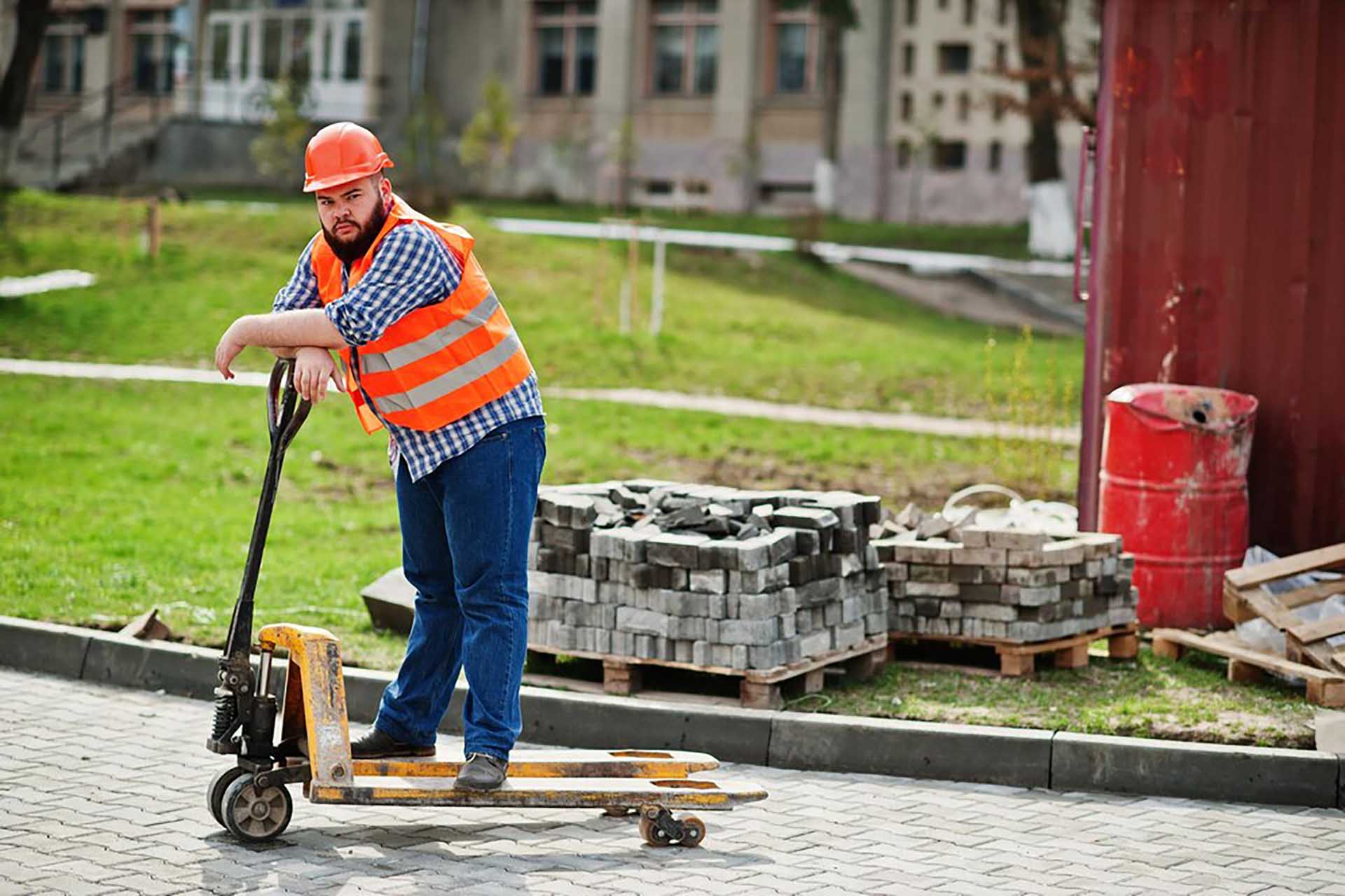 brutal-beard-worker-man-suit-construction-worker-safety-orange-helmet-with-pallet-truck_627829-11411